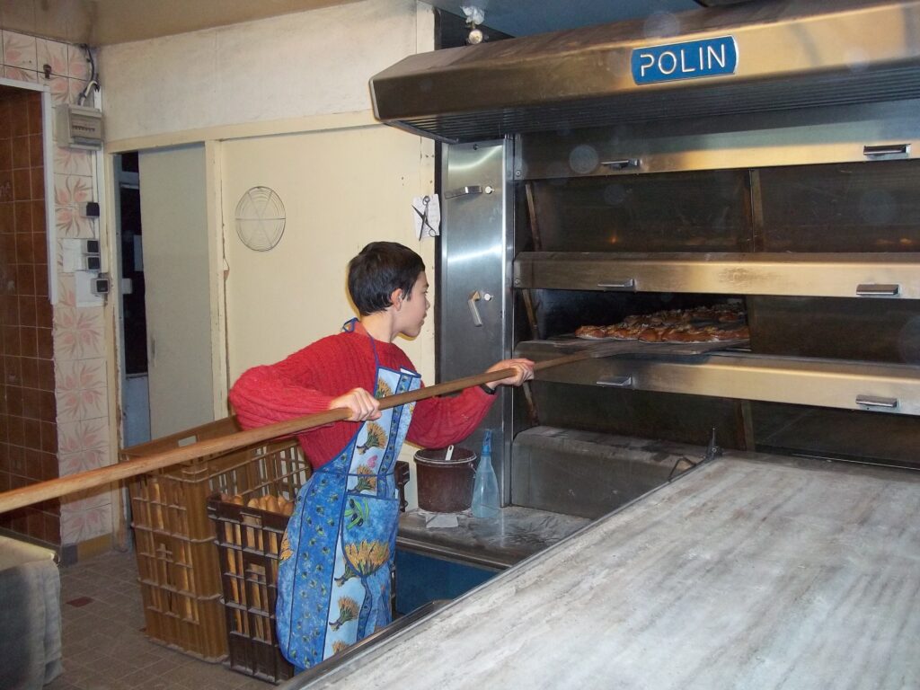 Un jeune déjà bien motivé par la boulangerie, enfourne dans un four Paulin 